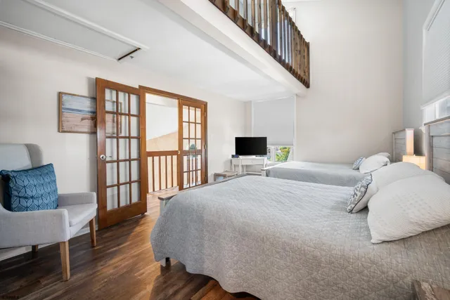 a bedroom with two beds and a flat screen tv