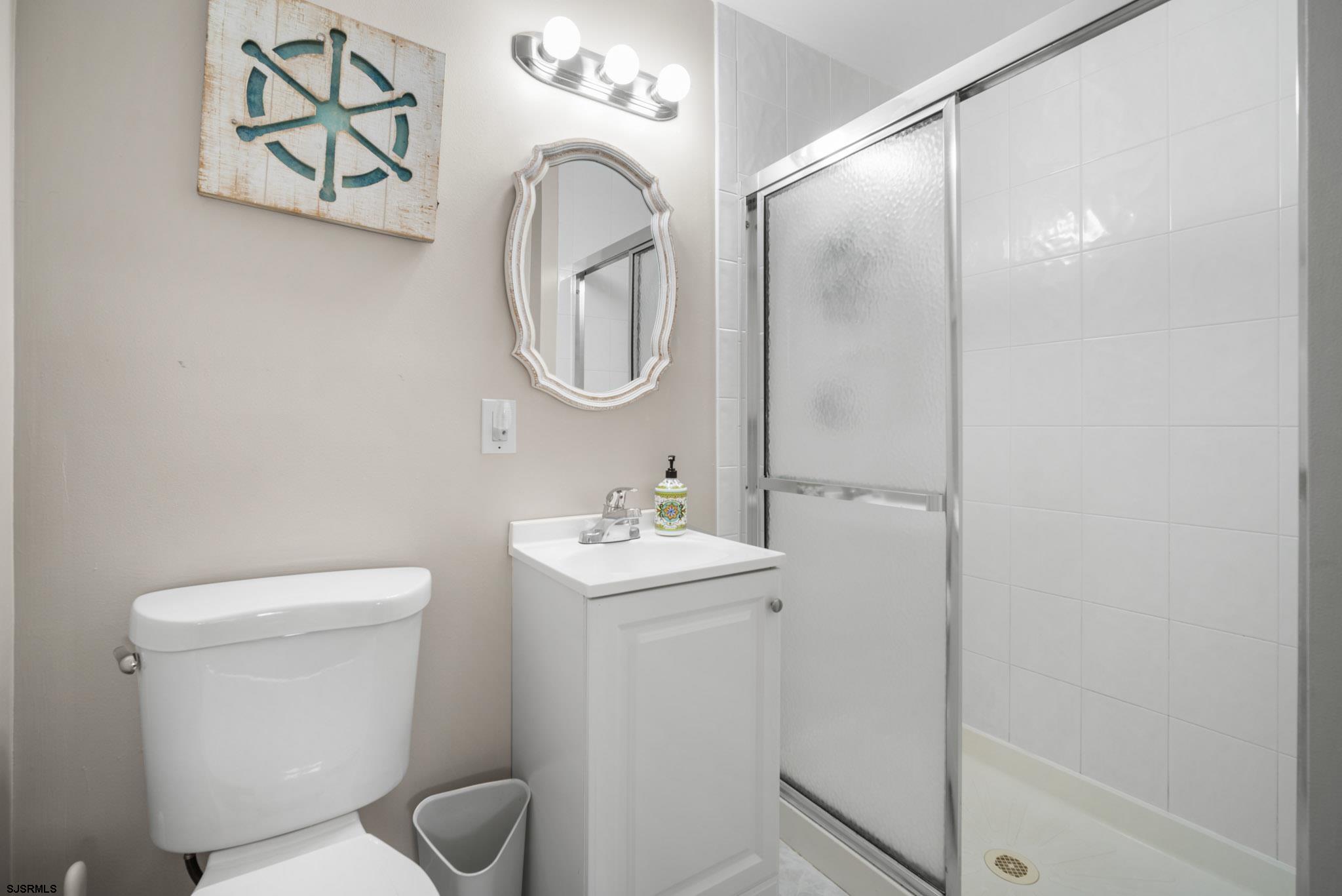 10 Explorer Road Brigantine, NJ 08203 - Photo 32 of 39 a bathroom with a toilet a sink and mirror