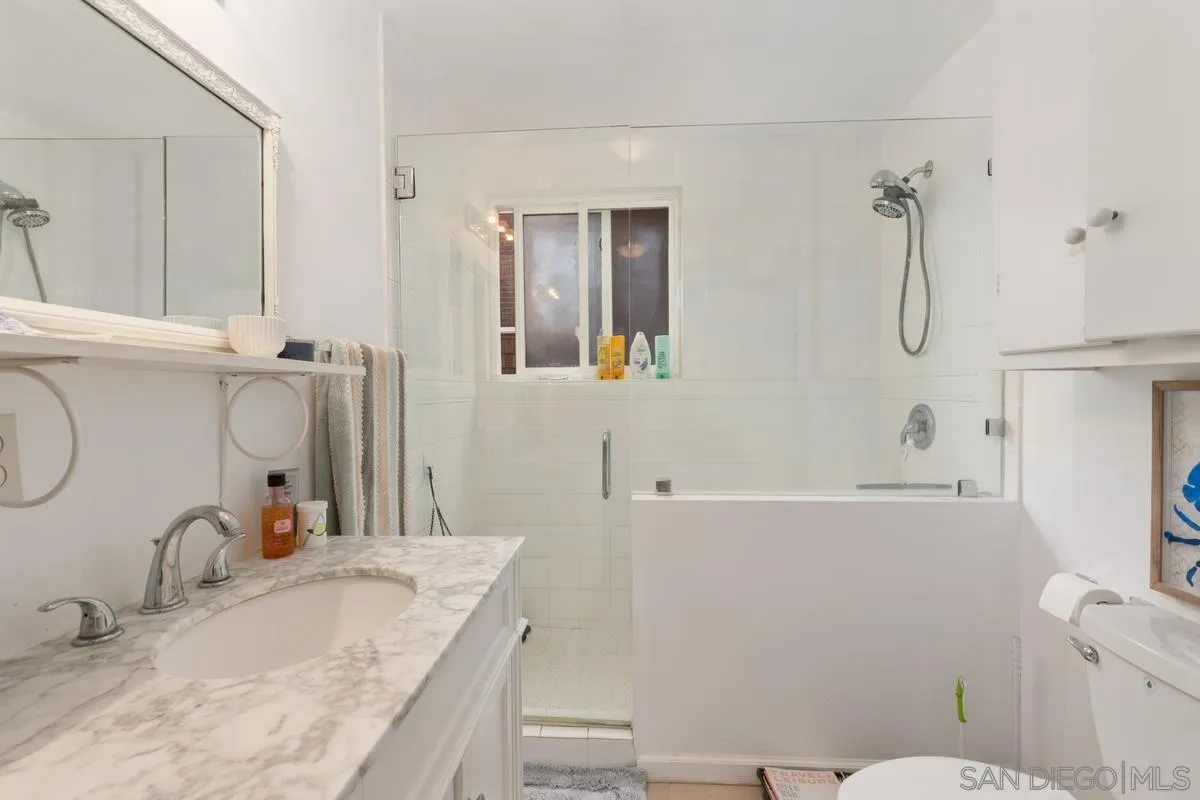 8040 Girard Avenue, Unit 2 La Jolla, CA 92037 - Photo 14 of 17 a bathroom with a granite countertop sink a toilet and shower