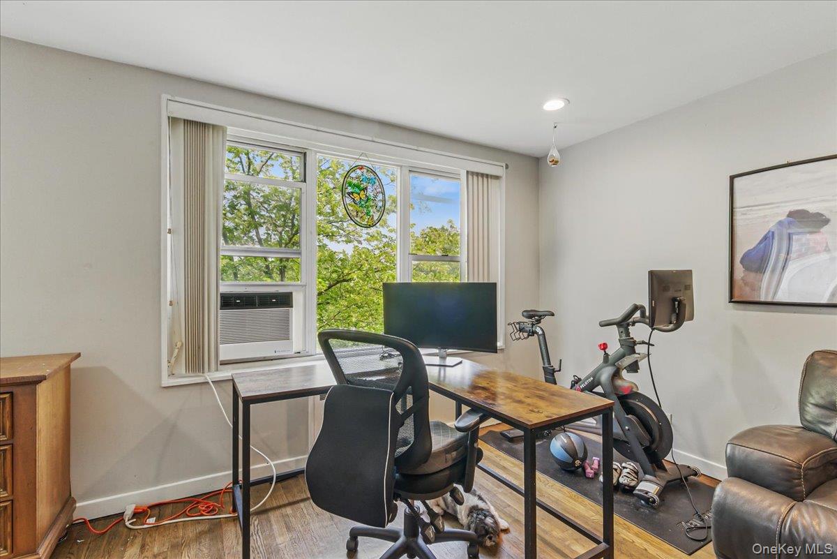 209-80 18th Avenue, Unit 4D Queens, NY 11360 - Photo 13 of 18 Office space featuring baseboards, wood finished floors, and cooling unit