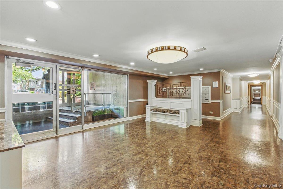 209-80 18th Avenue, Unit 4D Queens, NY 11360 - Photo 2 of 18 Unfurnished living room featuring a decorative wall, a wainscoted wall, and ornamental molding