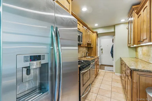 a kitchen with stainless steel appliances granite countertop a refrigerator and a stove