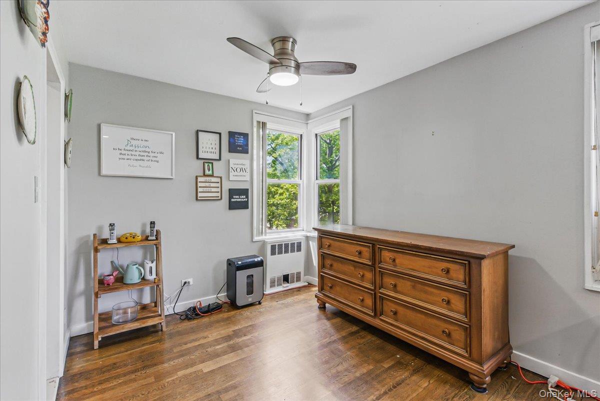 209-80 18th Avenue, Unit 4D Queens, NY 11360 - Photo 9 of 18 Bedroom with radiator, dark wood-type flooring, baseboards, and ceiling fan