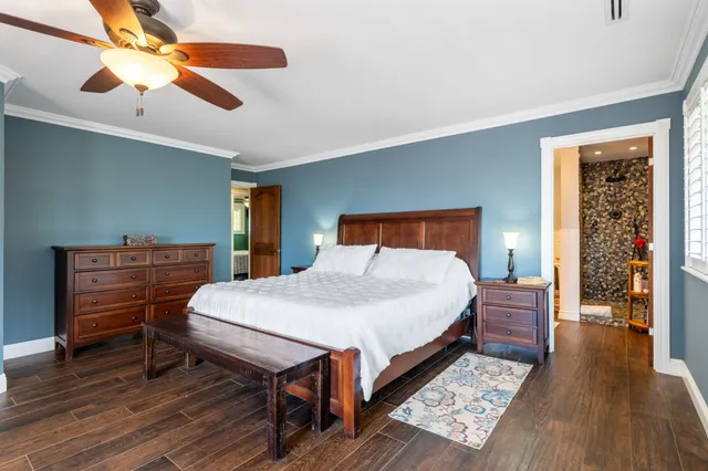 a bedroom with a bed and a wooden floor