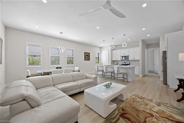 a living room with furniture kitchen view and a window