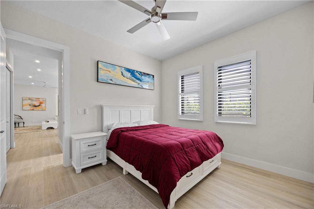 5832 Jasper Way, Unit 5102 Naples, FL 34114 - Photo 18 of 24 a bedroom with a bed and a chandelier