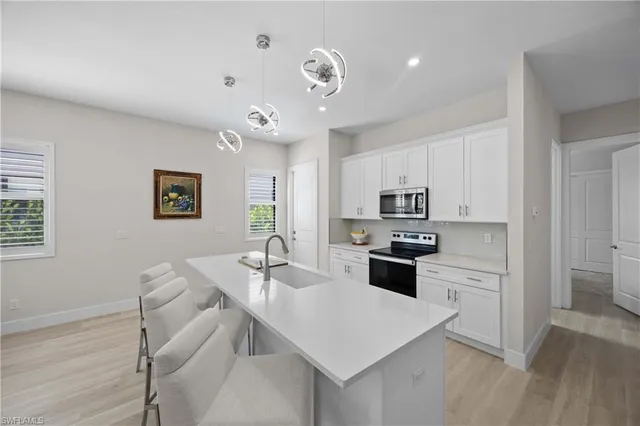 a kitchen with a refrigerator a stove a sink a dining table and chairs