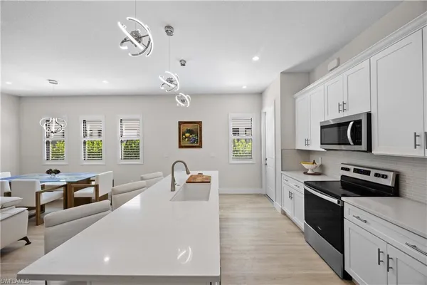 a large white kitchen with stainless steel appliances