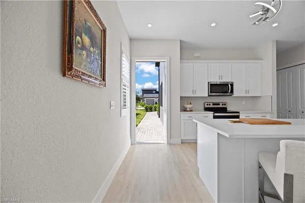 a kitchen with white cabinets and stainless steel appliances