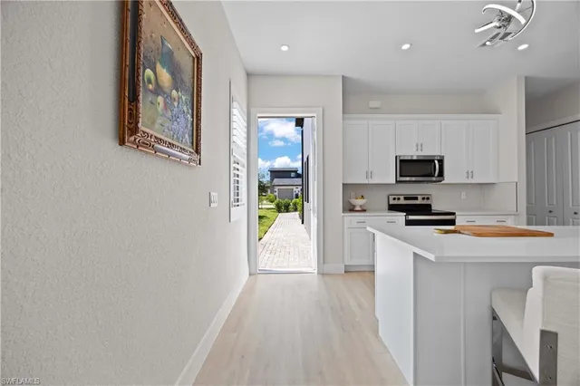a kitchen with white cabinets and stainless steel appliances