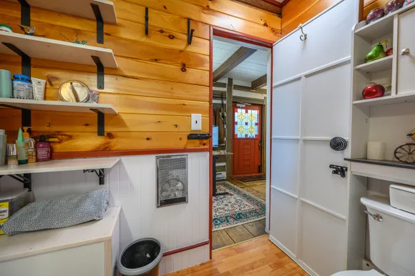 a open kitchen with white cabinets and wooden floor