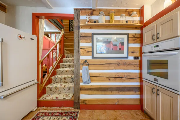 a view of a hallway with wooden floor and a dining room