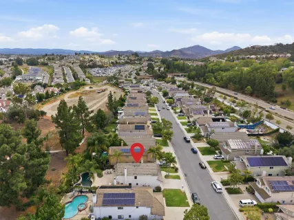 an aerial view of residential houses with outdoor space and street view