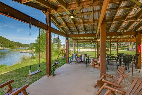a view of a patio with table and chairs next to an umbrella