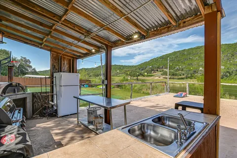 a view of a patio with a table chairs and a barbeque