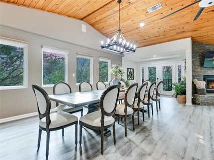 a dining room with furniture a chandelier and wooden floor