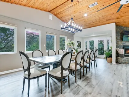 a dining room with furniture a chandelier and wooden floor