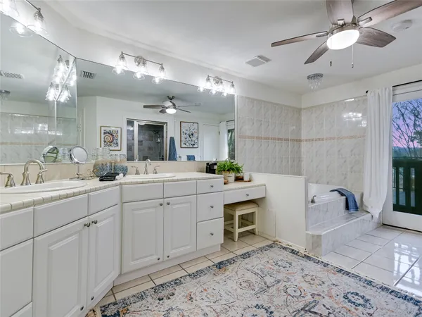 a spacious bathroom with a sink a large mirror and shower