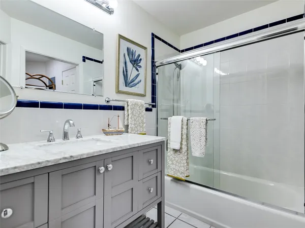 a bathroom with a granite countertop sink mirror shower and double