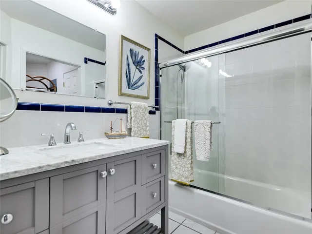 a bathroom with a granite countertop sink mirror shower and double