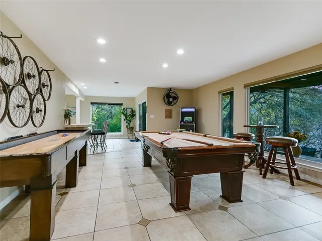 a dining hall with stainless steel appliances granite countertop a barbecue grill and couches with wooden floor