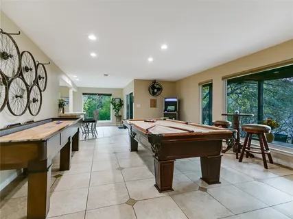 a dining hall with stainless steel appliances granite countertop a barbecue grill and couches with wooden floor