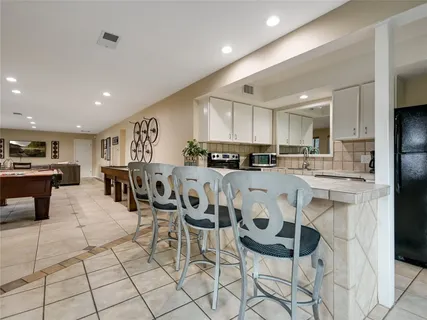 a large kitchen with a table and chairs