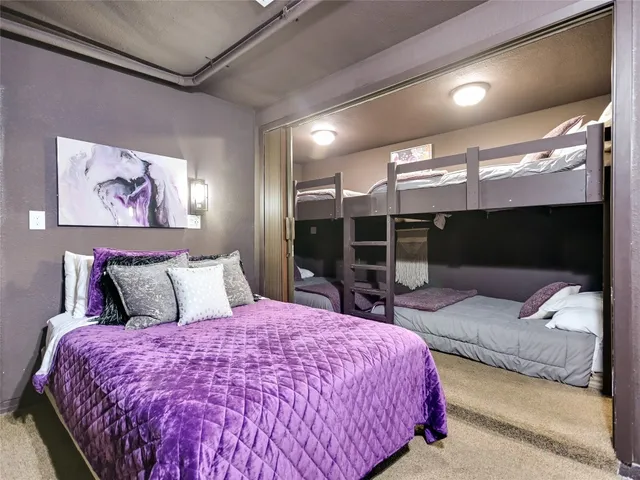 a spacious bedroom with a large bed and a large mirror