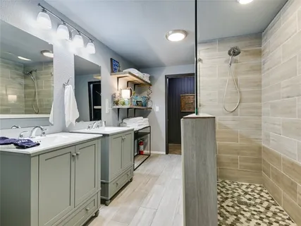 a bathroom with a granite countertop sink mirror and shower