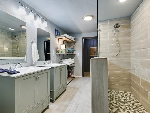 a bathroom with a granite countertop sink mirror and shower