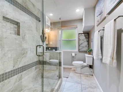 a bathroom with a toilet a sink and a shower