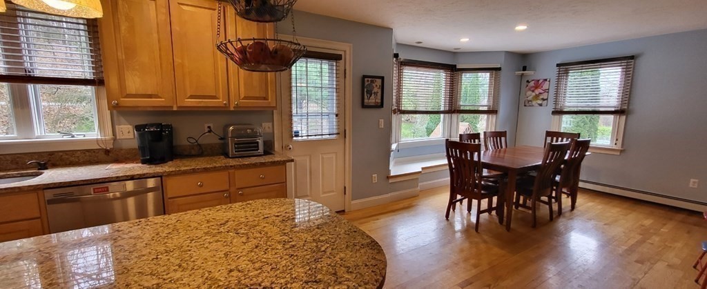 60 Marble Road Sutton, MA 01590 - Photo 7 of 21 a kitchen with stainless steel appliances granite countertop dining table chairs and wooden floor