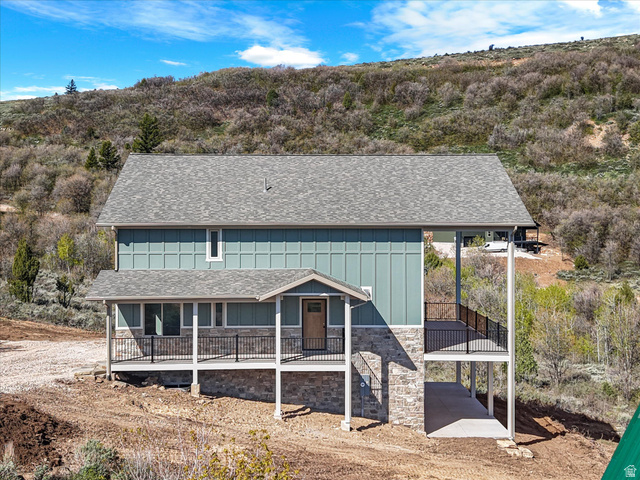 1159 North Broad Hollow Road Garden City, UT 84028 - Photo 19 of 55 Two-story home featuring a gray shingle roof, light blue vertical siding, and a stone facade foundation