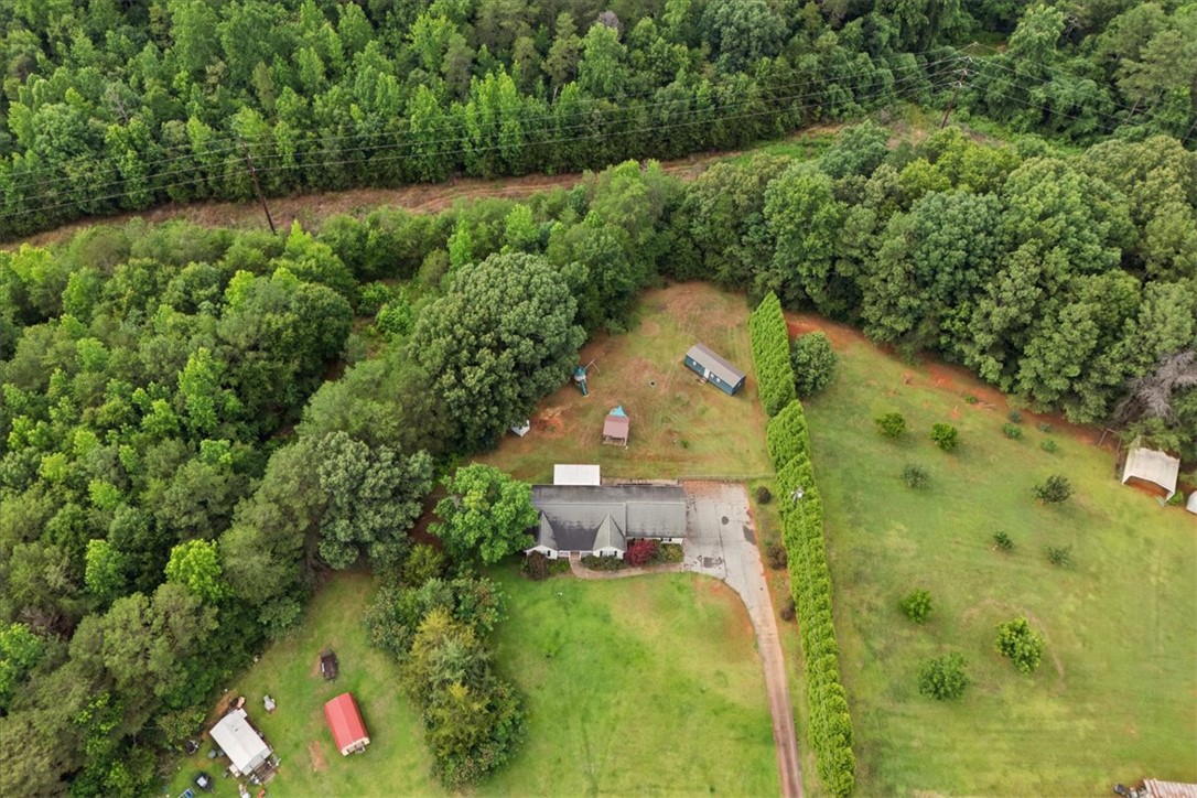 520 Sharon Lane Seneca, SC 29678 - Photo 47 of 48 An aerial perspective reveals a secluded property amidst lush woodlands, with a private driveway leading to the residence.