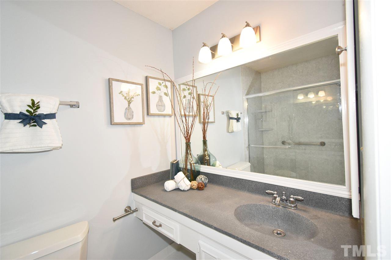 710 Green Ridge Drive Raleigh, NC 27609 - Photo 13 of 26 a bathroom with a granite countertop sink a mirror and a shower