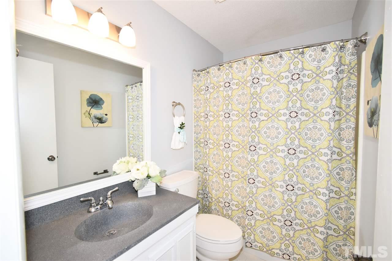 710 Green Ridge Drive Raleigh, NC 27609 - Photo 15 of 26 a bathroom with a sink a toilet and shower curtain