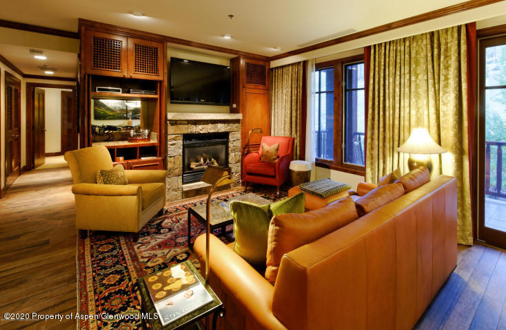 75 Prospector Road, Unit 8310 Aspen, CO 81611 - Photo 2 of 11 a living room with furniture a flat screen tv and a fireplace