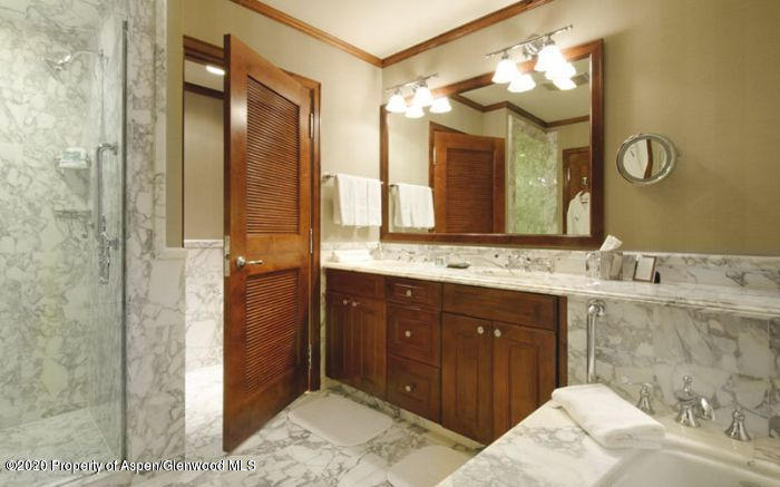 75 Prospector Road, Unit 8310 Aspen, CO 81611 - Photo 6 of 11 a bathroom with a granite countertop sink a mirror and a shower