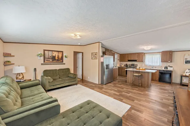 a living room with furniture and kitchen view