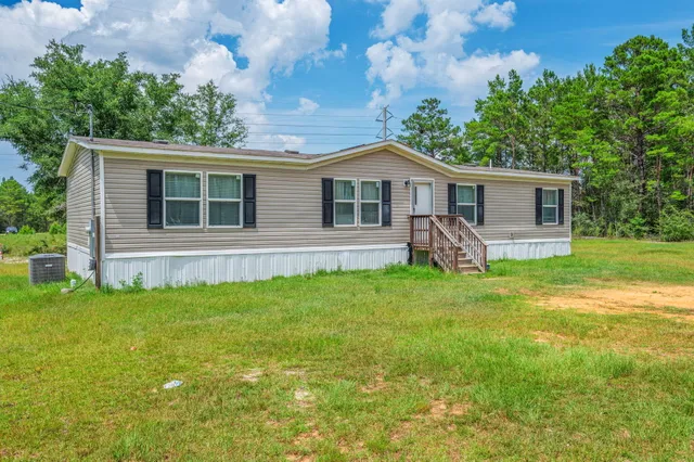 a view of house with a backyard
