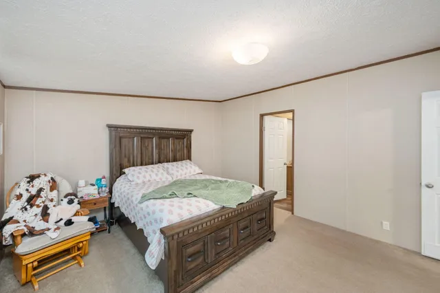 a bed sitting in a spacious bedroom next to a window