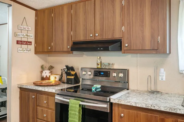 a kitchen with stainless steel appliances granite countertop a stove a cabinets and a refrigerator