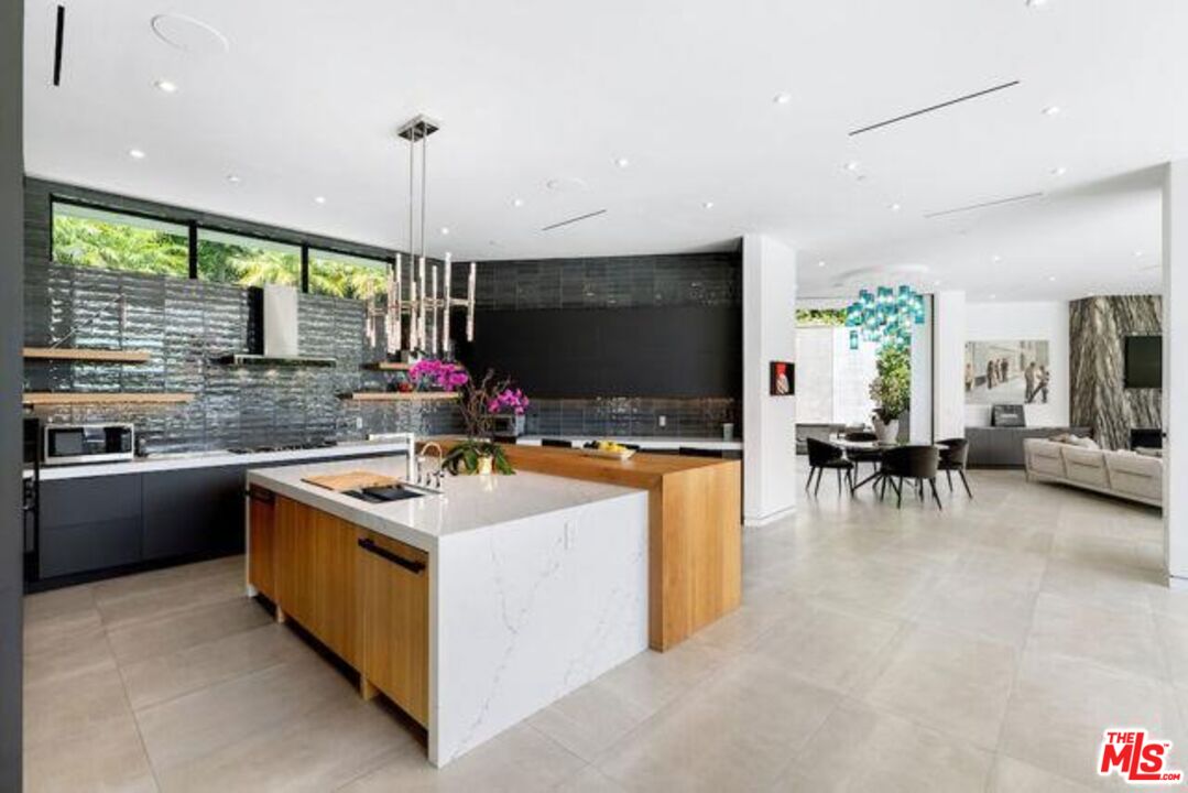 Undisclosed Address Beverly Hills, CA 90210 - Photo 23 of 47 a kitchen with stainless steel appliances granite countertop a stove and a view of living room