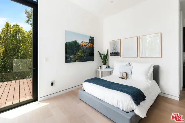 a bedroom with a bed lamp and mirror