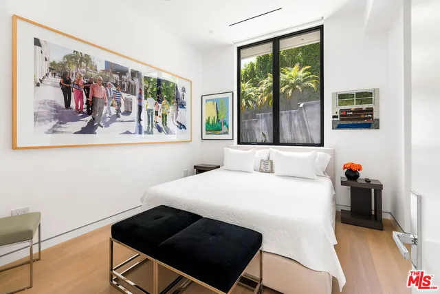 a bedroom with a bed and a large window with outer view