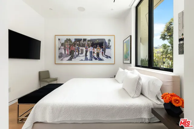 a bedroom with a large bed and a flat screen tv