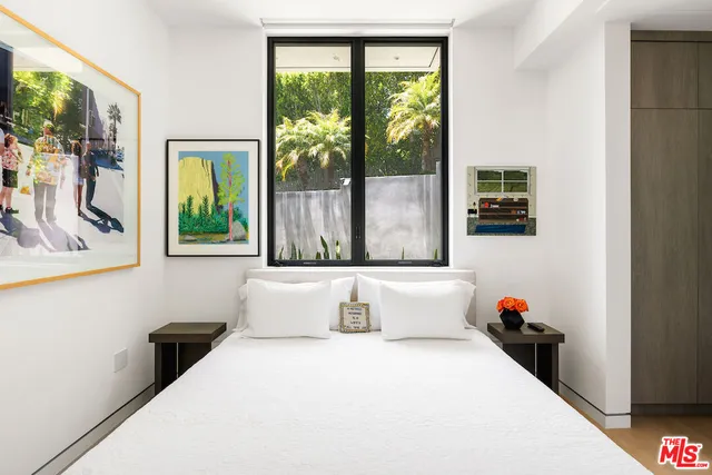 a bedroom with a bed and a large window