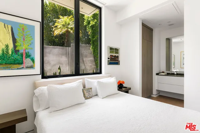 a bedroom with a bed and a large window