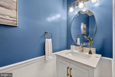 a bathroom with a sink a light fixture and a mirror