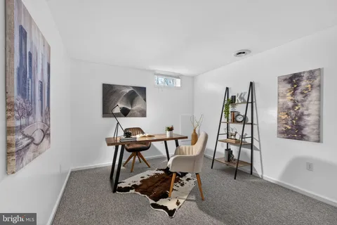 a view of a workspace with furniture and a window